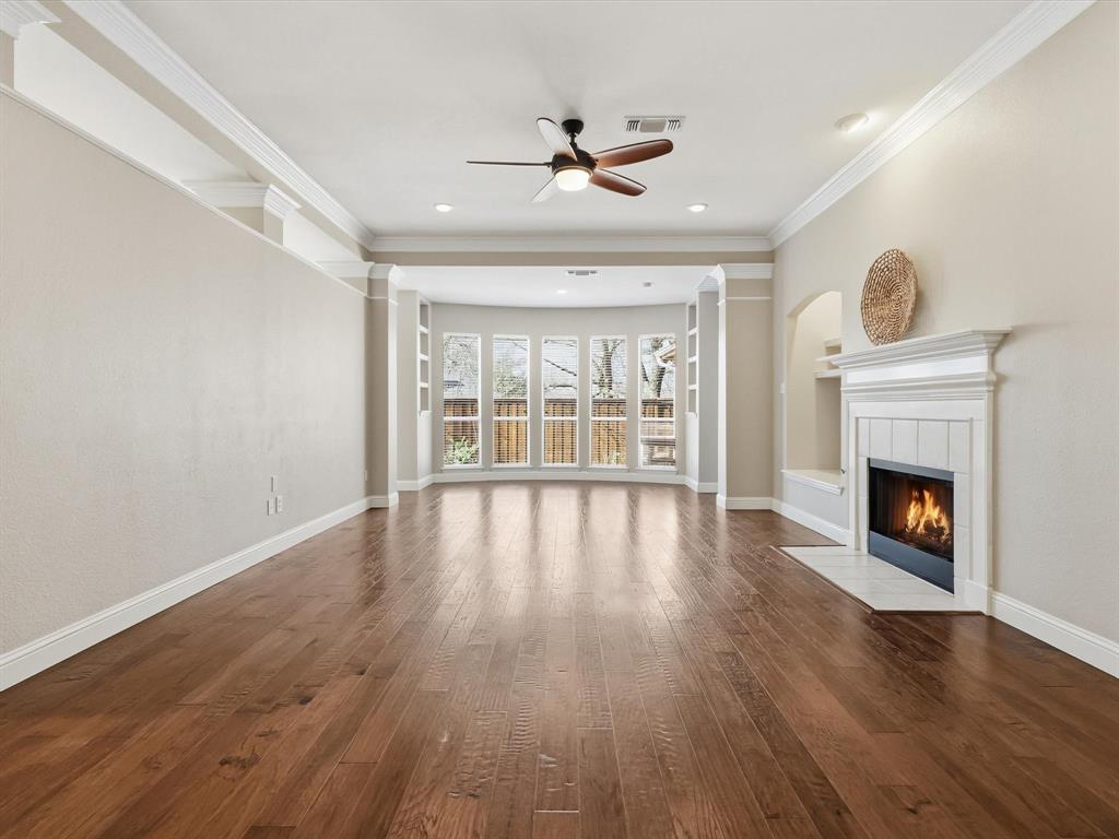 2211 Post Oak Circle Corinth, TX 76210 - Photo 21 of 40 a view of an empty room with wooden floor fireplace and a window
