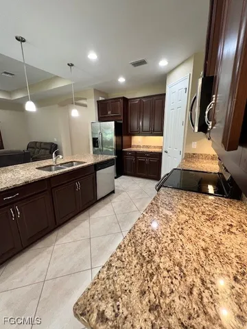a kitchen with stainless steel appliances kitchen island granite countertop a sink and cabinets