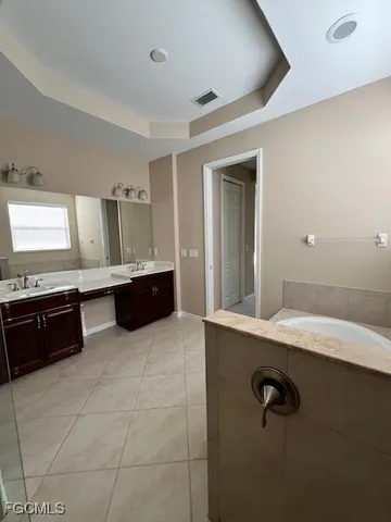 a bathroom with a tub sink and mirror