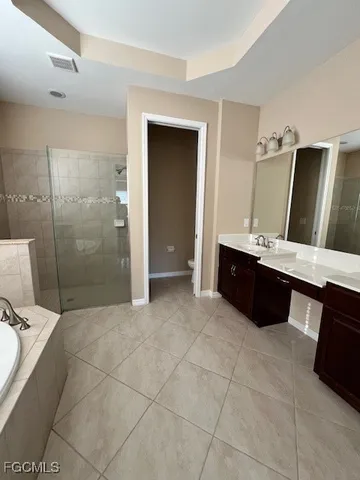 a spacious bathroom with a bathtub sink and mirror