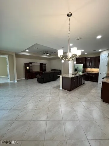 a kitchen with kitchen island granite countertop a stove and a sink