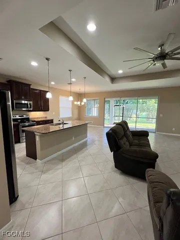 a large kitchen with granite countertop a stove a sink dishwasher and a refrigerator