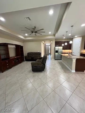 a large living room with stainless steel appliances kitchen island granite countertop a large counter top and couches