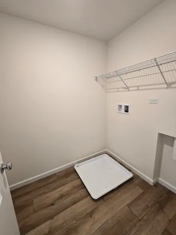 an empty room with wooden floor and fan