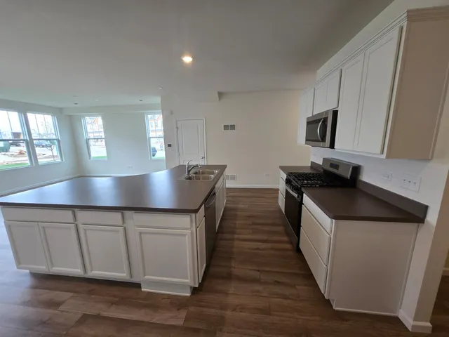 a kitchen with counter top space and wooden floor