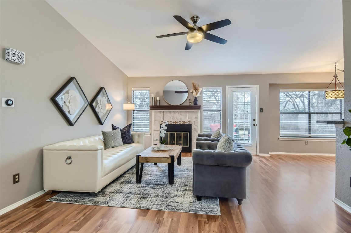 a living room with furniture a fireplace and a large window