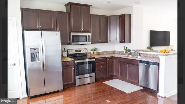 a kitchen with stainless steel appliances granite countertop a refrigerator stove top oven and sink