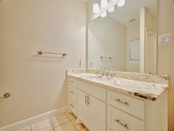 a bathroom with a granite countertop sink and a mirror