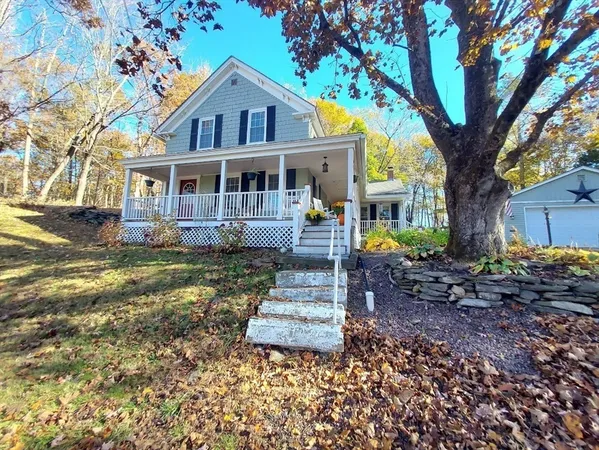 a front view of a house with a garden and trees