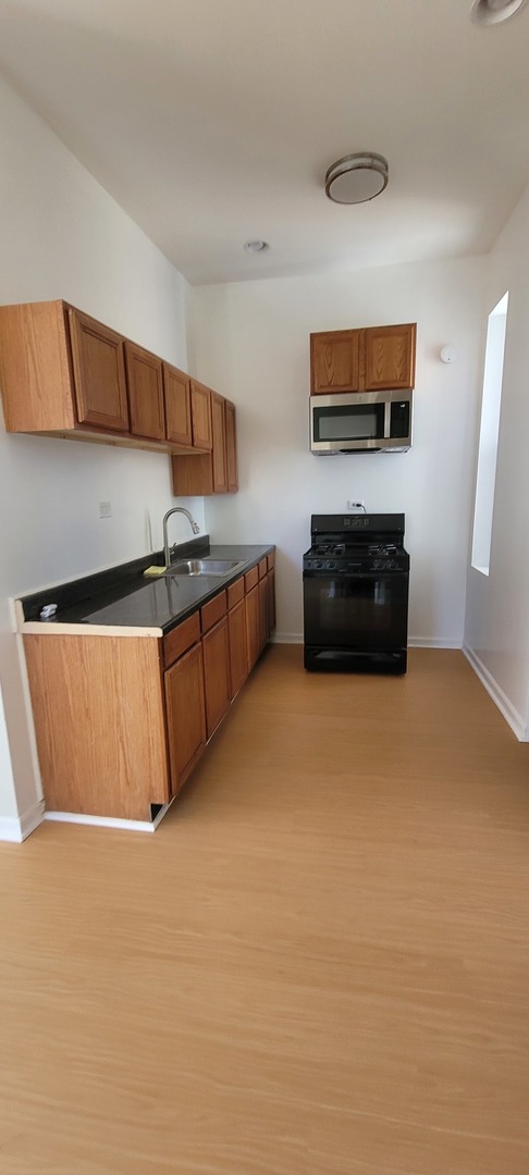 Undisclosed Address Chicago, IL 60624 - Photo 5 of 10 a kitchen with stainless steel appliances granite countertop a stove and a refrigerator