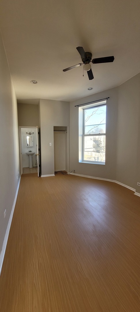 Undisclosed Address Chicago, IL 60624 - Photo 10 of 10 an empty room with a fireplace and windows