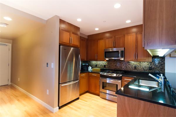 80 Broad Street, Unit 603 Boston, MA 02110 - Photo 3 of 9 a kitchen with stainless steel appliances granite countertop a refrigerator a stove a sink and a microwave