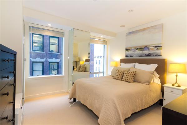 80 Broad Street, Unit 603 Boston, MA 02110 - Photo 5 of 9 a bed room with a bed and a night stand