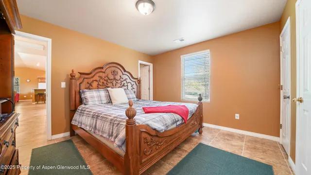 a bedroom with a bed and large windows