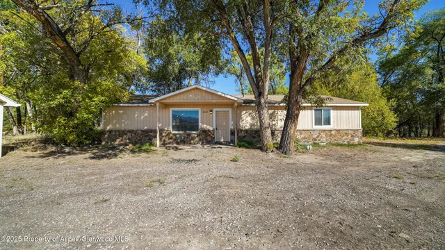 a front view of a house with yard and green space