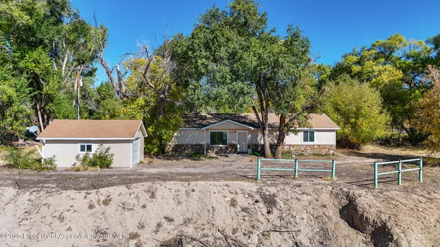a white house that has tree in front of it