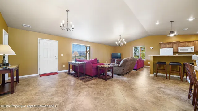 a spacious bedroom with bed and a chandelier