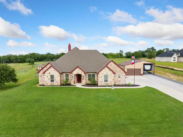 a view of a house with a big yard and large trees