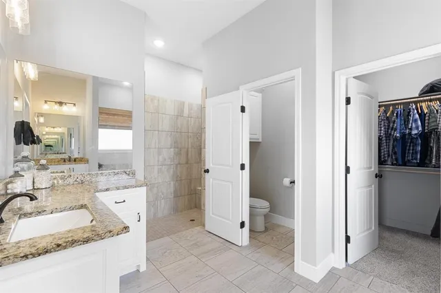 a bathroom with a granite countertop sink mirror and shower
