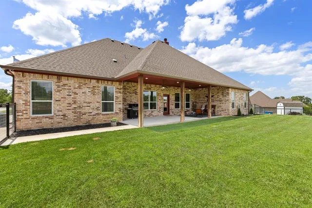 a view of a house with a big yard and large tree