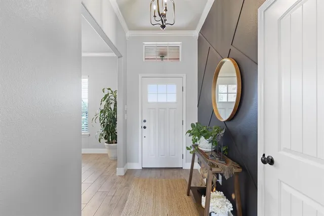 an entryway with wooden floor a glass table and chair