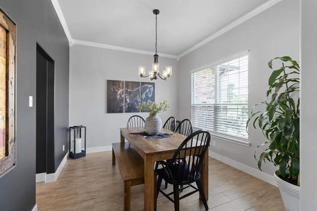 a dining room with furniture a chandelier and wooden floor