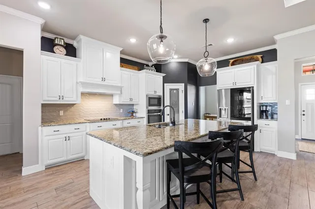 a kitchen with stainless steel appliances granite countertop a stove a sink and a refrigerator