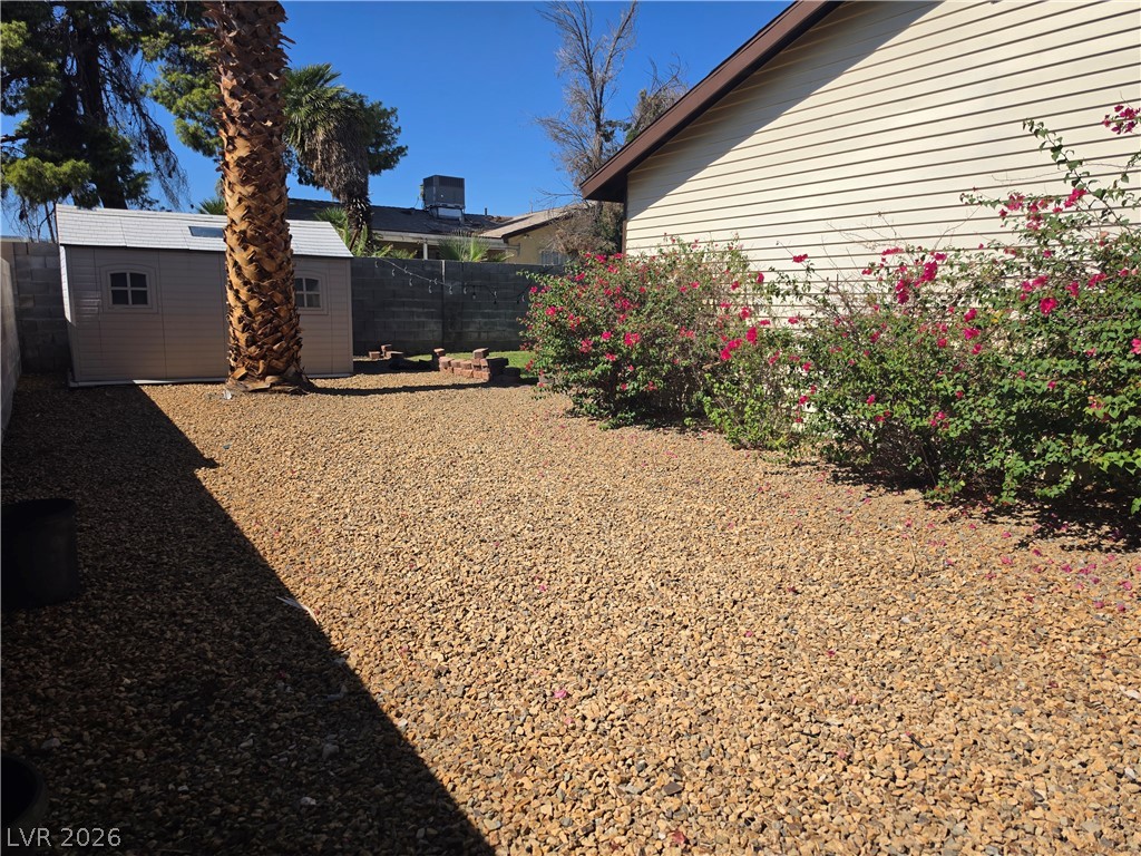 5289 Reeder Circle Las Vegas, NV 89119 - Photo 39 of 40 Low-maintenance gravel landscaping highlights this sunny outdoor space featuring a storage shed and mature plantings.
