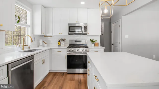 a kitchen with stainless steel appliances a stove microwave and sink