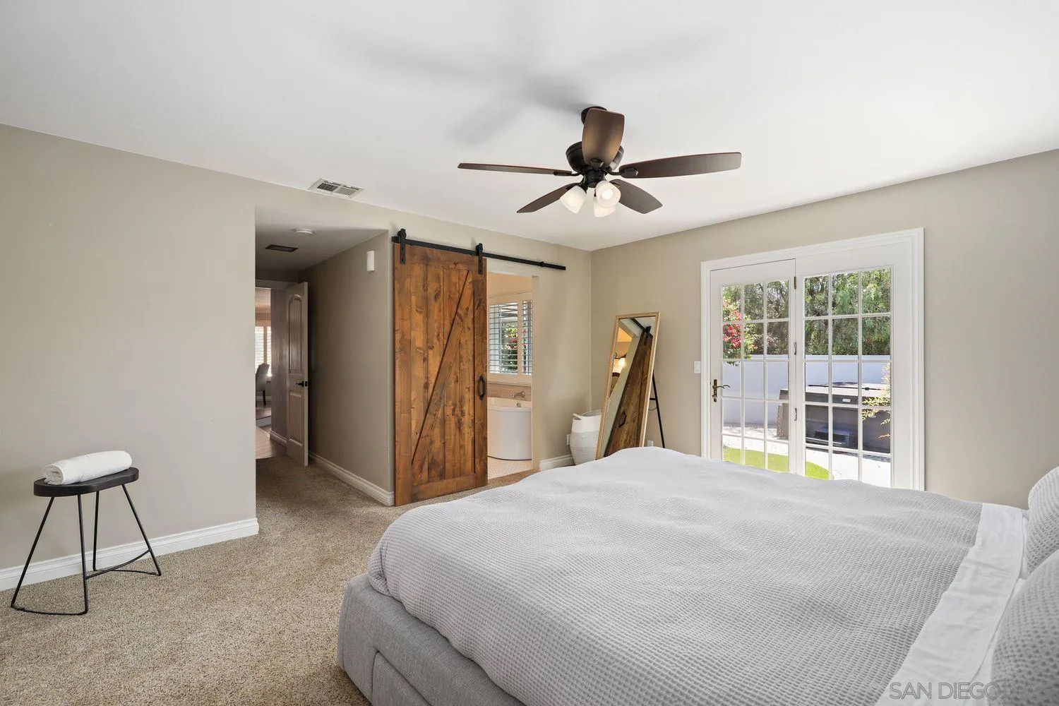 1921 Winterwarm Drive Fallbrook, CA 92028 - Photo 18 of 32 a bedroom with a large bed and a chandelier