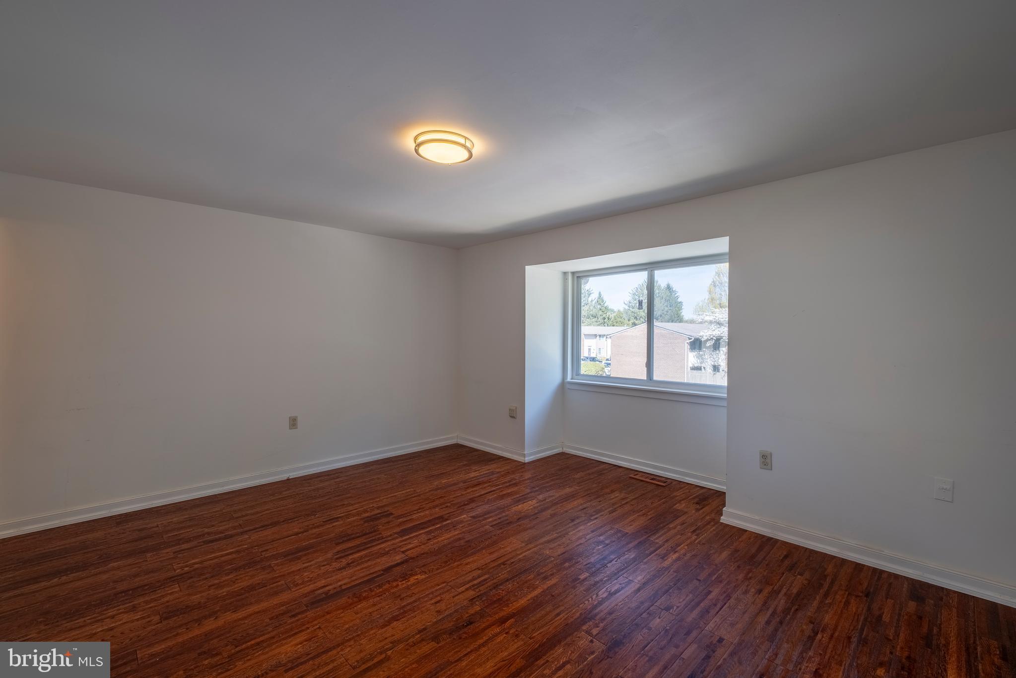 9637 Horizon Run Road, Unit 2H Montgomery Village, MD 20886 - Photo 17 of 28 a view of an empty room with wooden floor and a window