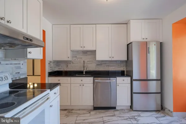 a kitchen with stainless steel appliances granite countertop a refrigerator sink and cabinets
