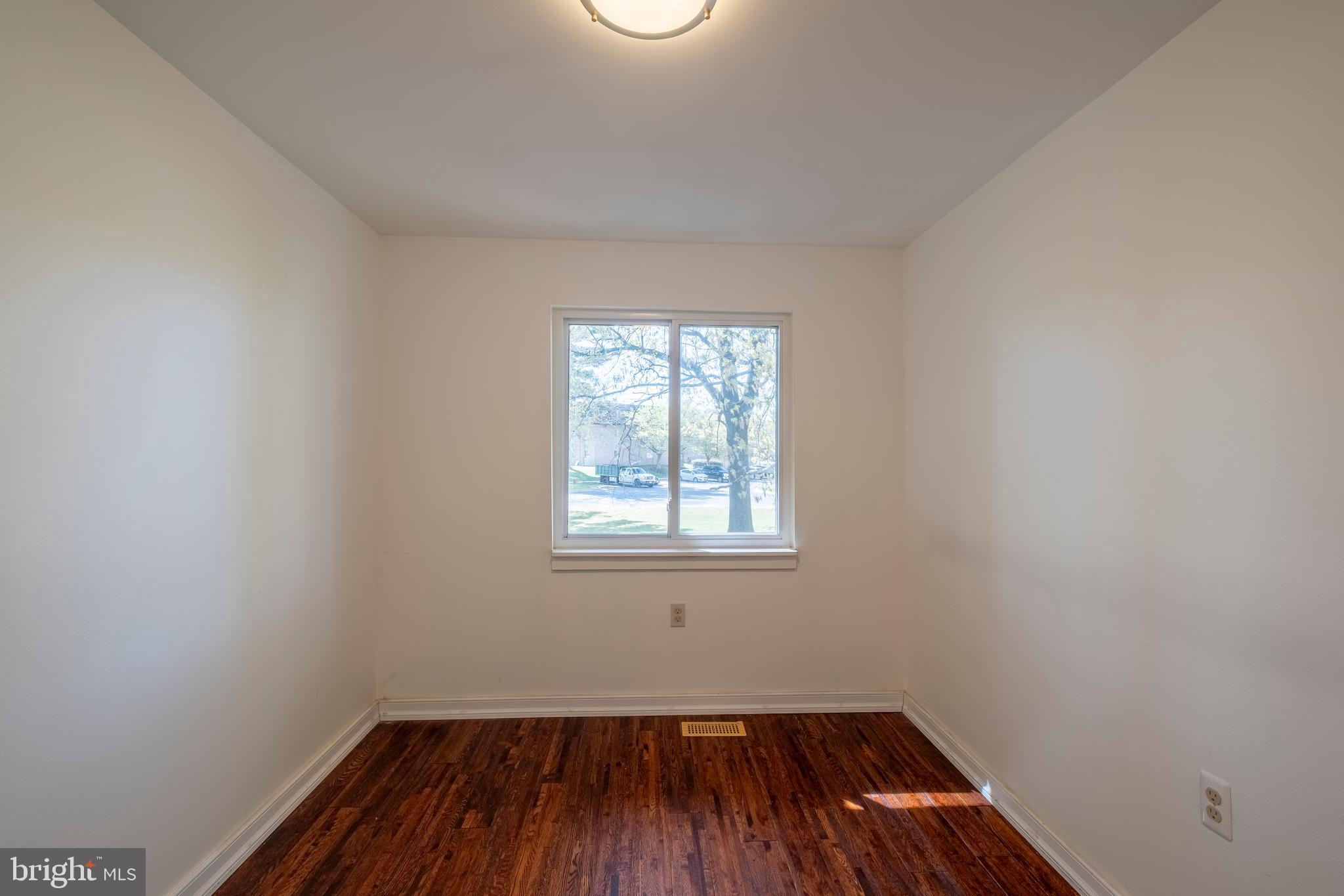 9637 Horizon Run Road, Unit 2H Montgomery Village, MD 20886 - Photo 22 of 28 an empty room with wooden floor and windows