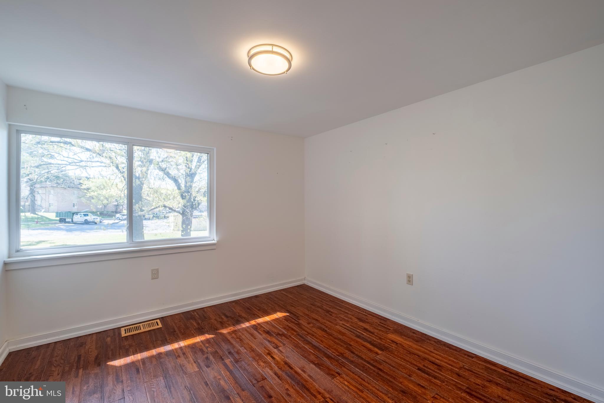 9637 Horizon Run Road, Unit 2H Montgomery Village, MD 20886 - Photo 24 of 28 an empty room with wooden floor and windows