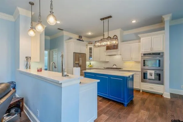 a large kitchen with kitchen island a large island in the center and stainless steel appliances