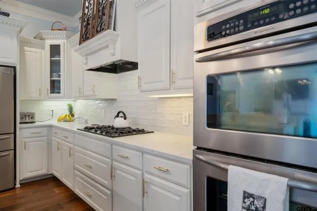 a kitchen with stainless steel appliances granite countertop a sink a stove and cabinets