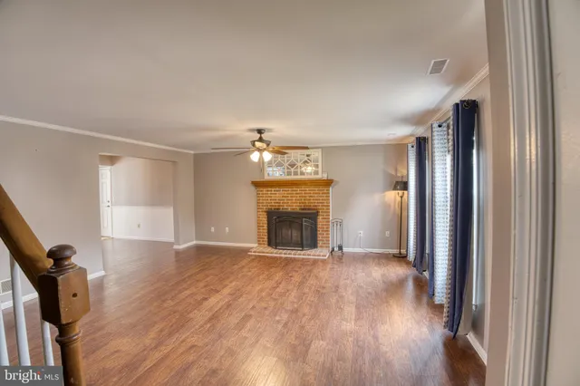 a view of an empty room with a fireplace and a window