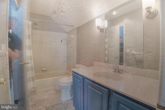 a bathroom with a granite countertop sink a toilet and shower
