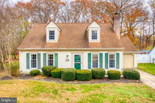 a view of a house with a big yard and large tree and plants