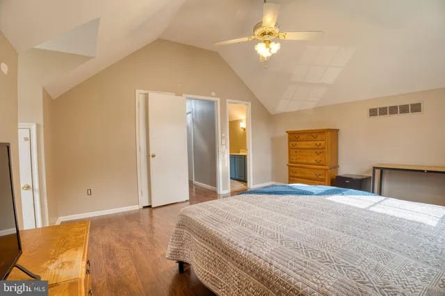 a bedroom with a bed closet and a chandelier