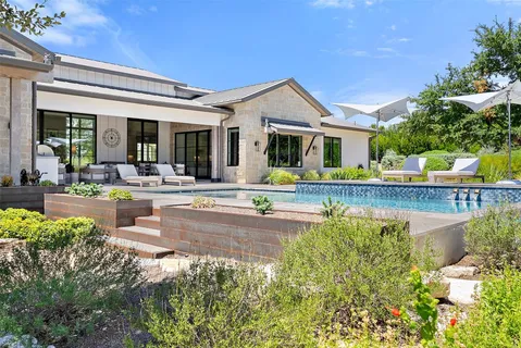 a front view of a house with swimming pool and porch with furniture