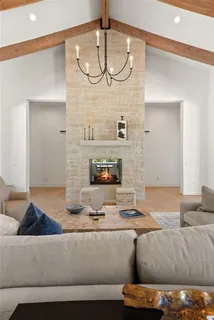 a open kitchen with a refrigerator a sink dishwasher a dining table and chairs with wooden floor