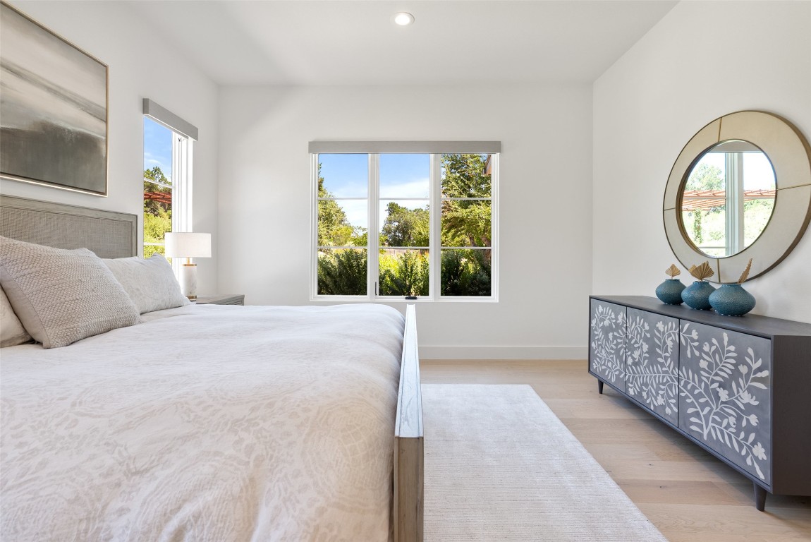 15236 Grumbles Lane Austin, TX 78738 - Photo 25 of 37 a bedroom with a bed a dresser next to a window