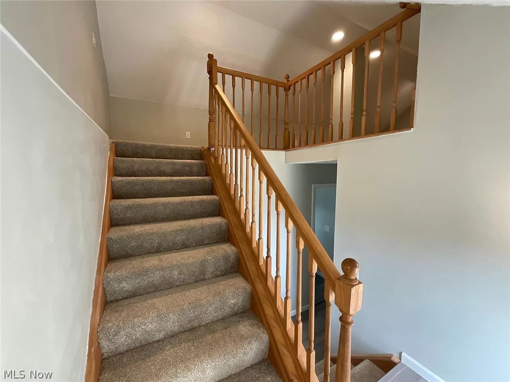 1850 Ronald Road Akron, OH 44312 - Photo 29 of 32 Staircase featuring carpet flooring and a high ceiling