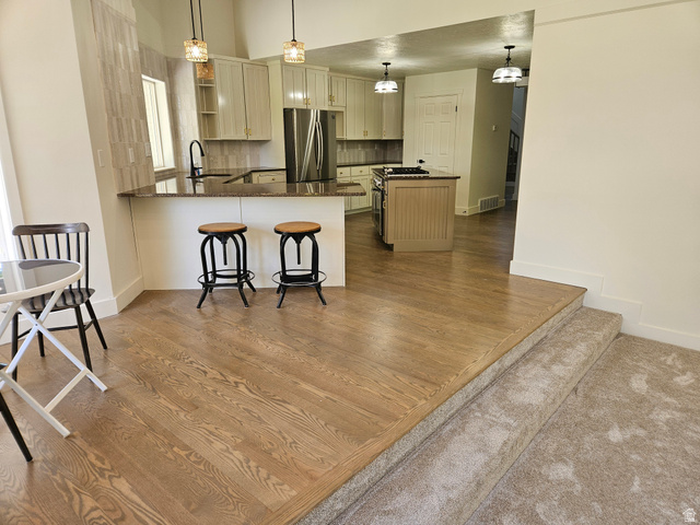 812 East Bates Cyn Road Tooele, UT 84074 - Photo 29 of 144 Contemporary kitchen featuring light cabinetry, dark countertops, a tile backsplash, and stainless steel appliances
