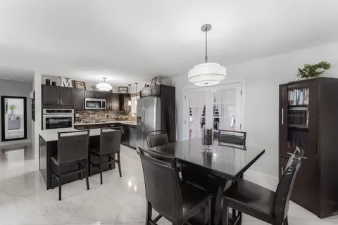 a dining room with a wooden table and chairs