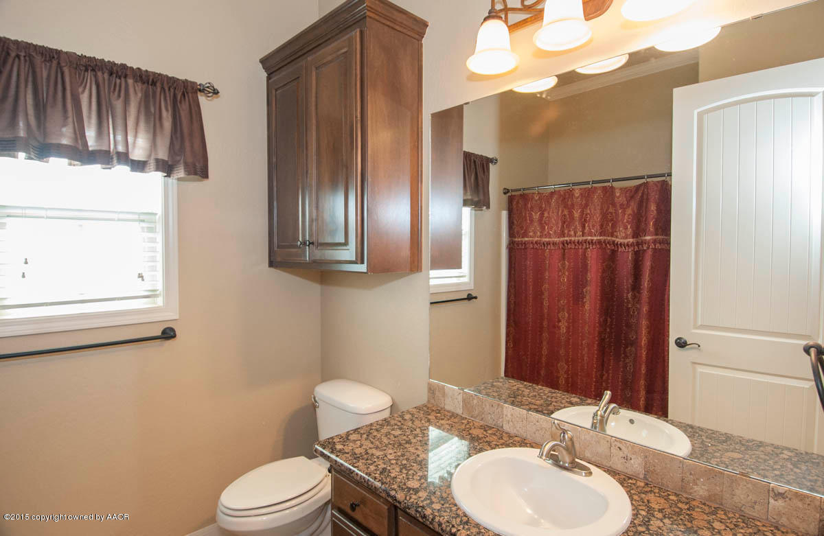3817 Arden Road Amarillo, TX 79118 - Photo 19 of 30 a bathroom with a toilet a sink and mirror