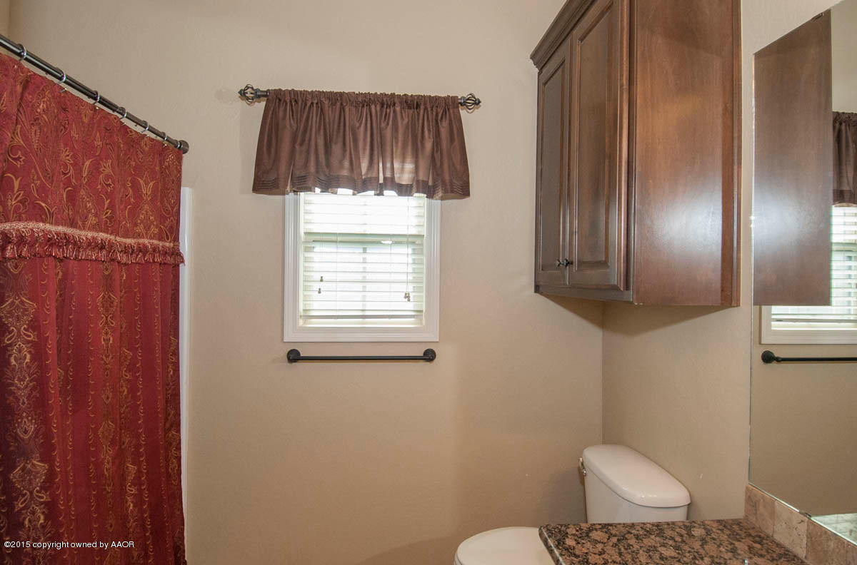 3817 Arden Road Amarillo, TX 79118 - Photo 20 of 30 a bathroom with a toilet a sink and a mirror