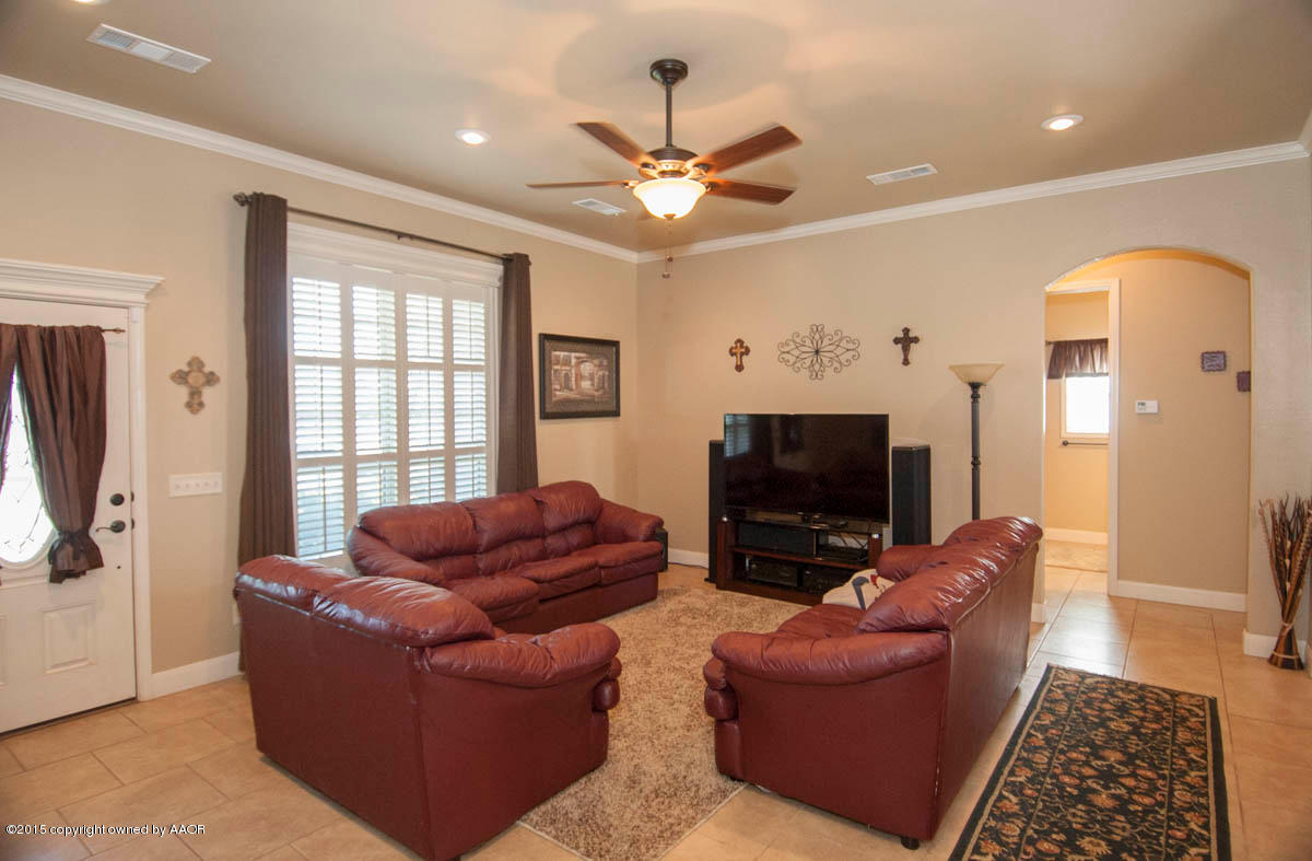3817 Arden Road Amarillo, TX 79118 - Photo 3 of 30 a living room with furniture a fireplace and a flat screen tv