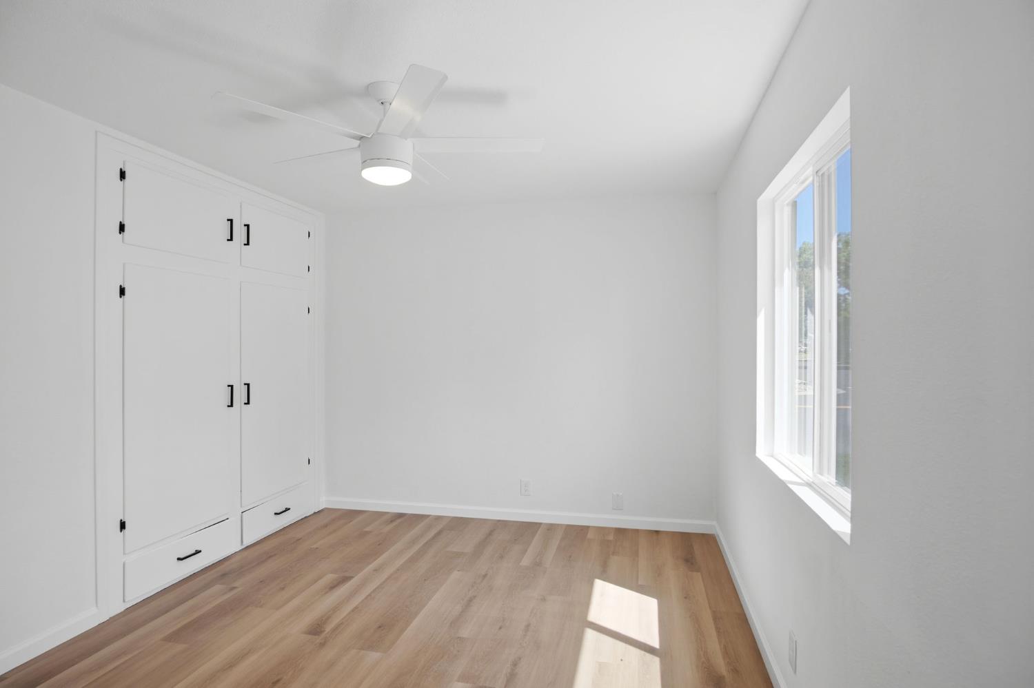 1451 Kent Way Modesto, CA 95355 - Photo 24 of 37 a view of an empty room with wooden floor and a window
